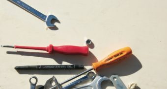 A number of tools lie scattered on a surface, potentially sold by Grainger Canada.