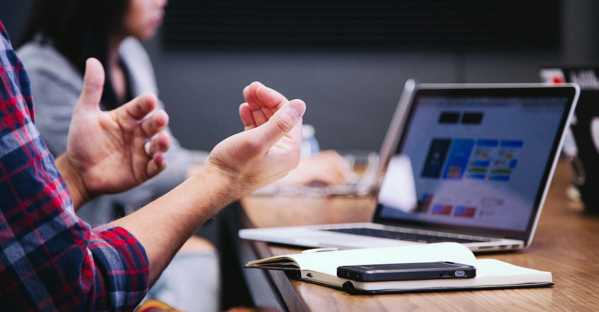 A number of professionals engage in discussions at a table.