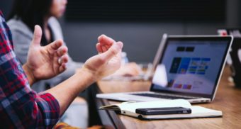 A number of professionals engage in discussions at a table.