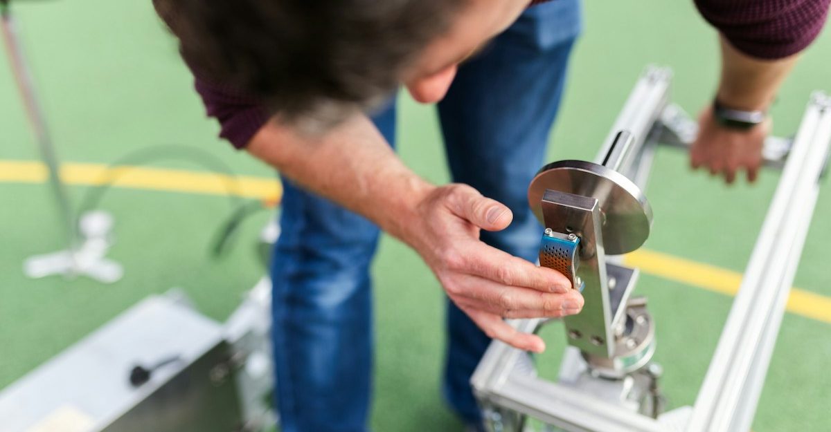 A quality assurance engineer examines a device their company is developing.