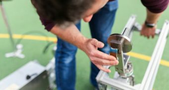 A quality assurance engineer examines a device their company is developing.