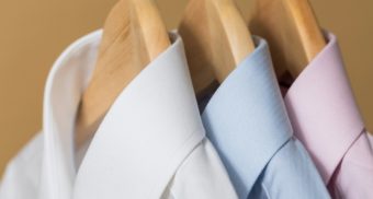 A close-up of three dress shirts on hangers, potentially sold by Simons.