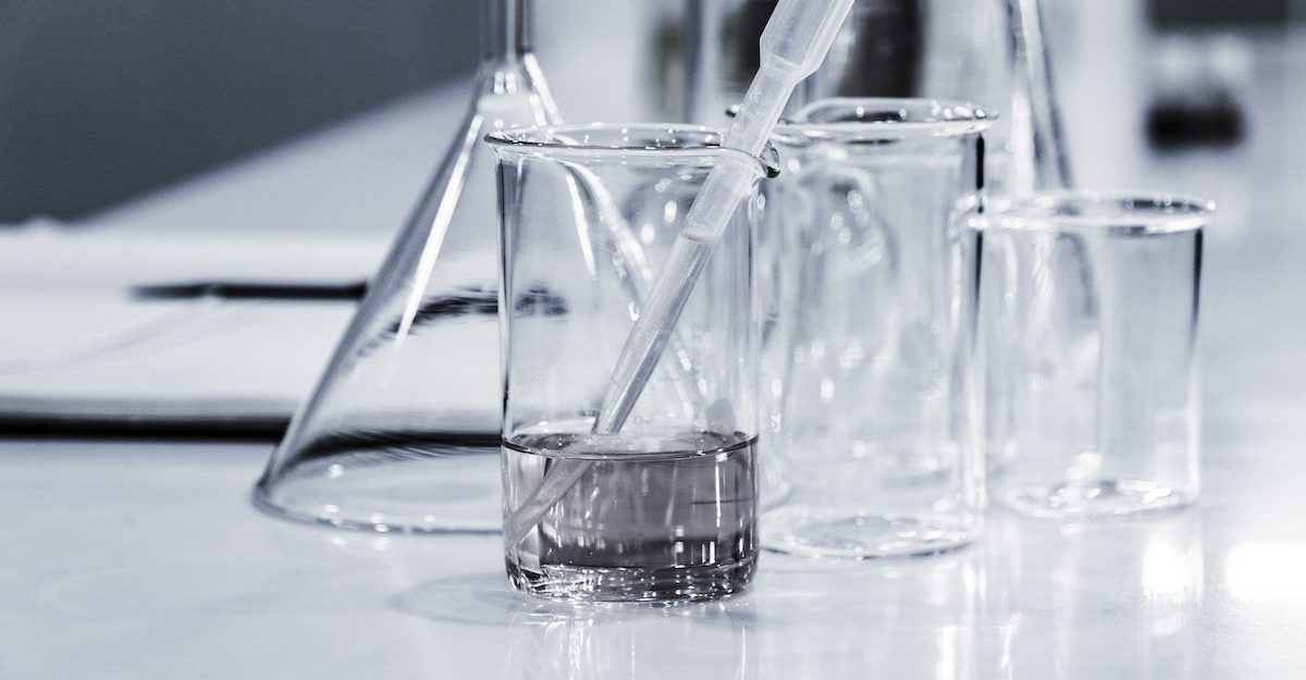 A number of glass flasks and graduated cylinders, potentially used by STEMCELL Technologies, sit on a table.