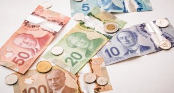 A photo of Canadian currency on a table. (Photo: PiggyBank / Unsplash)