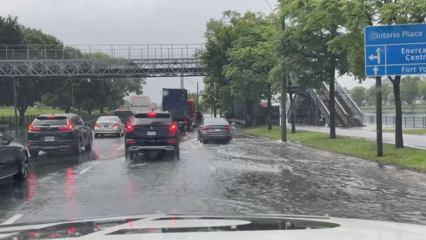 Vehicles navigate a flooded road near Ontario Place in Toronto.