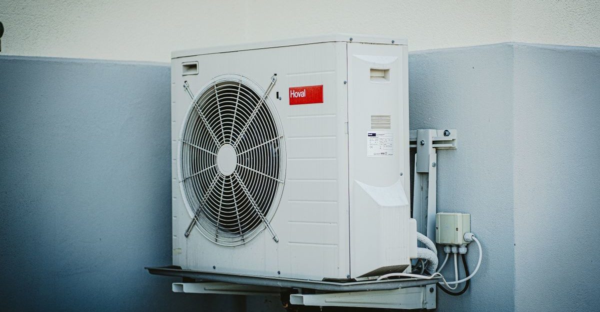 An air conditioning unit, potentially provided by a Carrier employee, is attached to a wall.