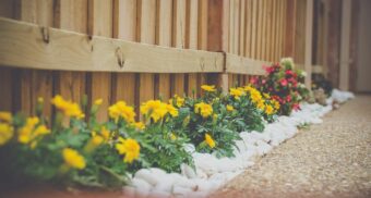 Flowers beautifully line a wooden fence in a design potentially created by NAK. (Photo: Matt Chen / Unsplash)