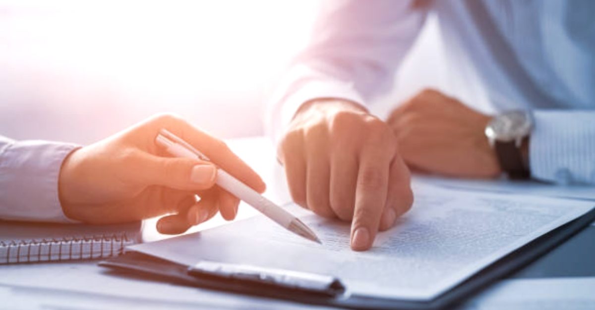 Two people examine an insurance document potentially provided by NFP Canada.