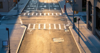 An empty intersection, typically used by cars, trucks, cyclists, motorcyclists, and pedestrians.