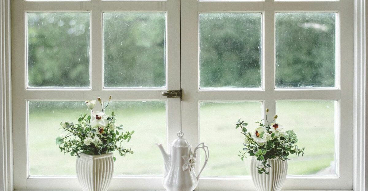 Vases and a teapot sit on a window sill.