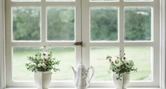 Vases and a teapot sit on a window sill.