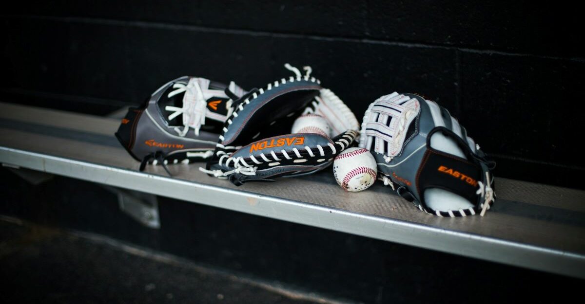 Baseball gloves and balls are seen on a bench.