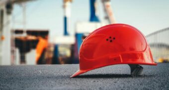 A hard helmet, potentially worn by a Voith employee, sits on the ground.