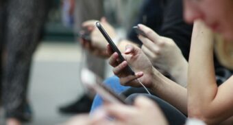 A photo of people interacting with their phones. (Photo: ROBIN WORRALL / Unsplash)