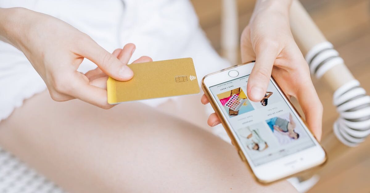 A woman makes an online payment with her smartphone, potentially facilitated by Interac.