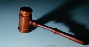 A photo of a wooden gavel on a marble table. (Photo: Wesley Tingey / Unsplash)