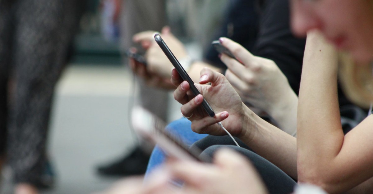 A photo of people interacting with their phones. (Photo: ROBIN WORRALL / Unsplash)