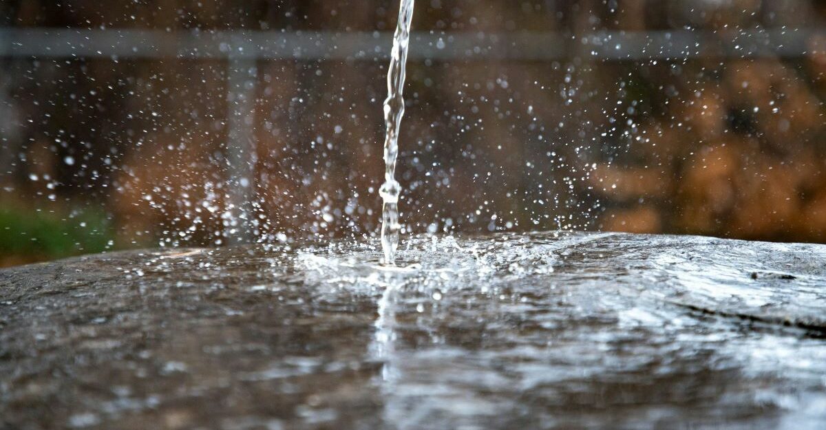 A stream of water splashes down on to a flat surface.