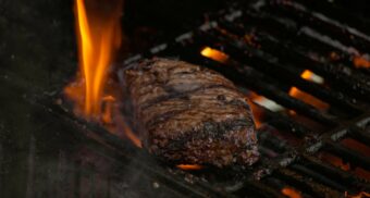 A photo of beef being cooked on a grill. (Photo: Tiitus Saaristo / Unsplash)