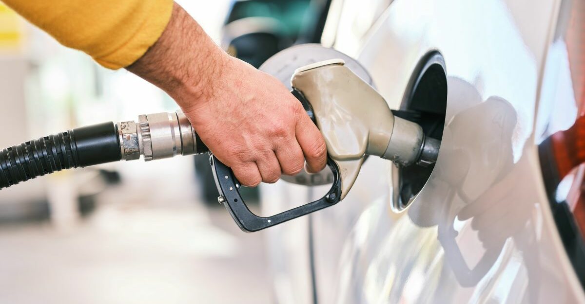 Somebody pumps fuel into the car, potentially at a Parkland-owned gas station.