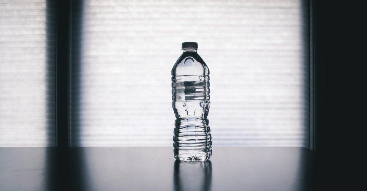 A lone, clear plastic water bottle sits on a surface.