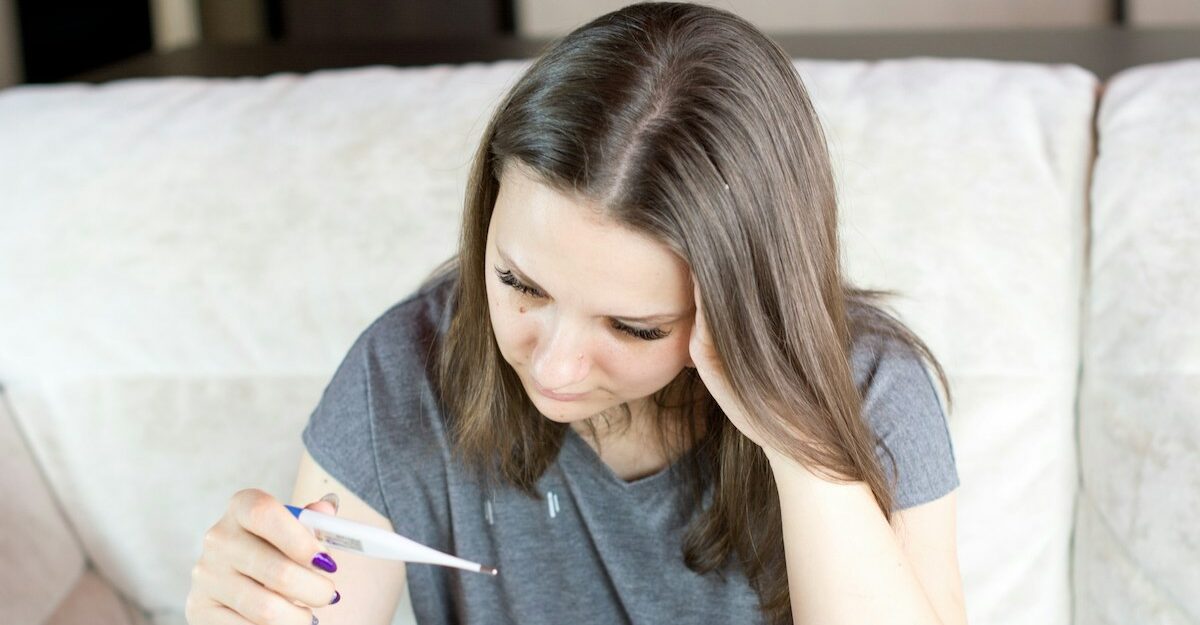 A sick woman in Ontario reads the results on a thermometer.