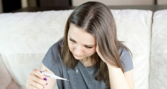 A sick woman in Ontario reads the results on a thermometer.