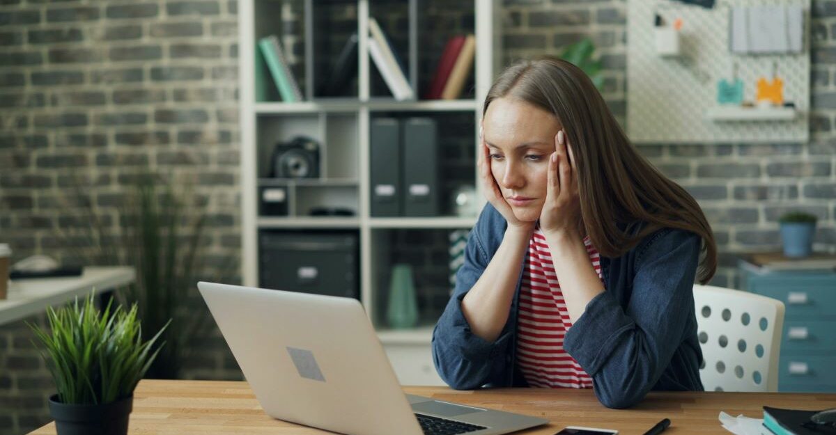 A distraught Ontario employee stares at her laptop after learning she has lost her job due to redundancy.