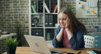 A distraught Ontario employee stares at her laptop after learning she has lost her job due to redundancy.