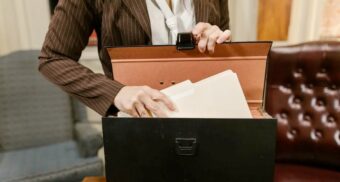 A photo of a person putting documents into a satchel. (Photo: Pexels / Google Images)