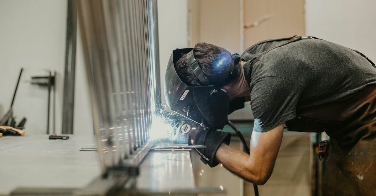 A welder seals two pieces of metal together.