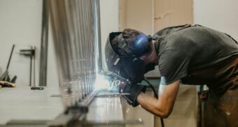 A welder seals two pieces of metal together.