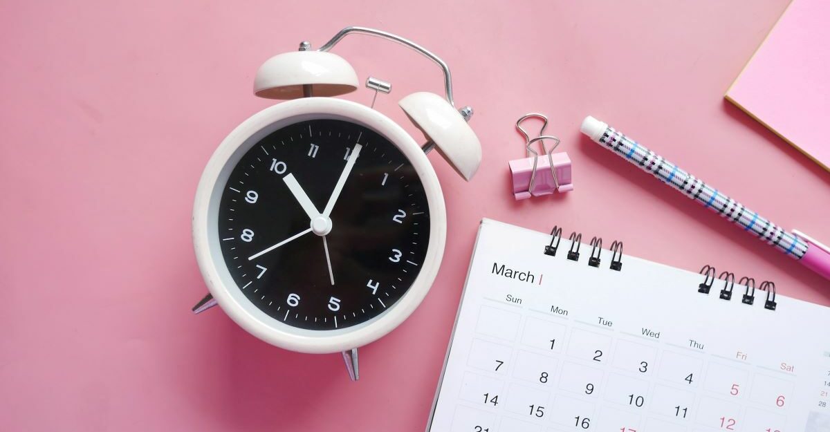 An alarm clock sits next to a calendar.