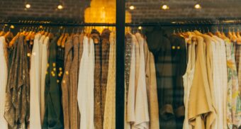 Clothes are hanging on a rack inside a retail store.