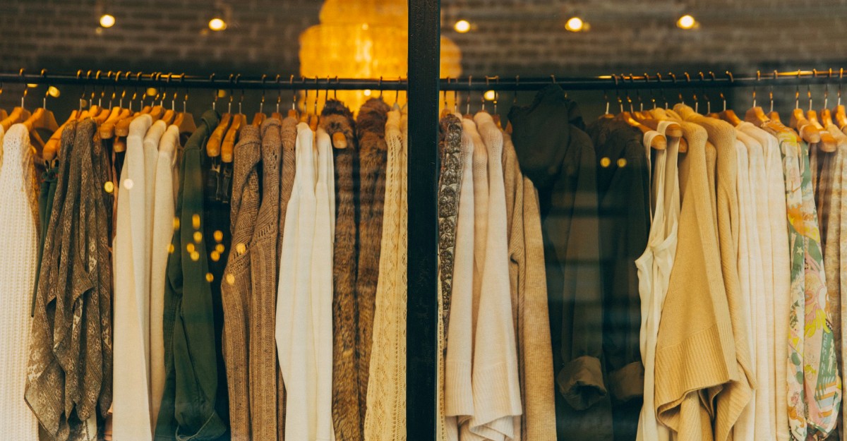 Clothes are hanging on a rack inside a retail store.