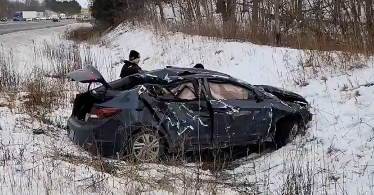 A photo of a dark-coloured sedan in a ditch beside Highway 403 in Hamilton. (Photo: OPP_HSD / X/Twitter)