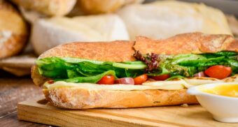 A photo of a submarine sandwich on a wooden table. (Photo: Raphael Nogueira / Unsplash)