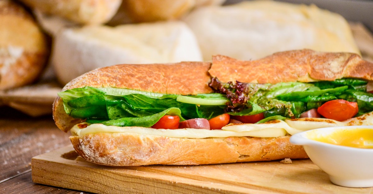 A photo of a submarine sandwich on a wooden table. (Photo: Raphael Nogueira / Unsplash)