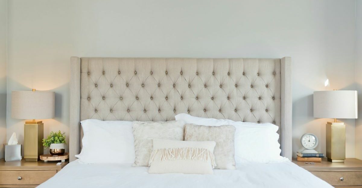 A carefully made bed is seen in a clean, white bedroom.