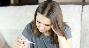 A sick woman in British Columbia reads the results on a thermometer.