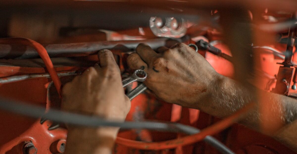 A photo of a mechanic working on a piece of machinery. (Photo: Nina Mercado / Unsplash)