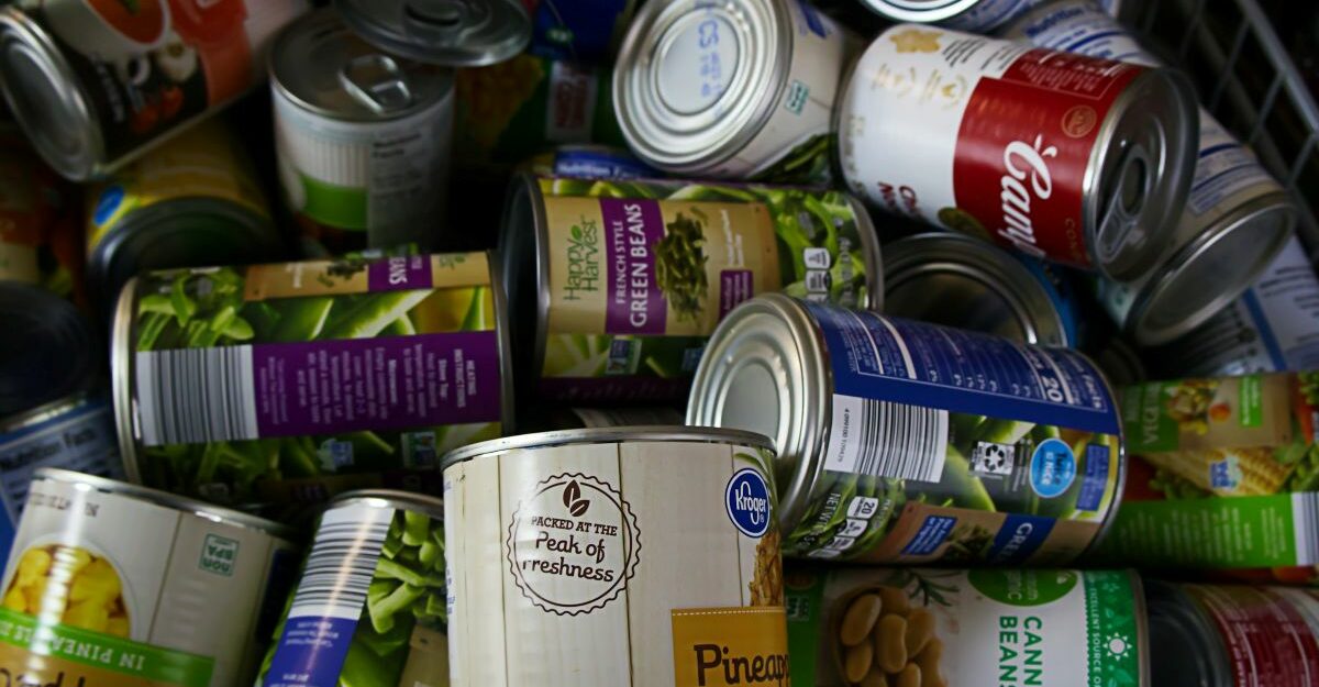 canned-food Numerous cans of food are seen piled on top of each other.