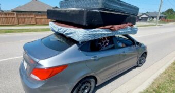 A photo of a grey Hyundai Accent with unsecured mattresses on the roof stopped by police in Paris, Ontario. (Photo: OPP)