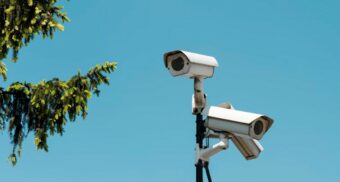 A photo of surveillance cameras beside a tree. (Photo: jaqbovsky / Unsplash)