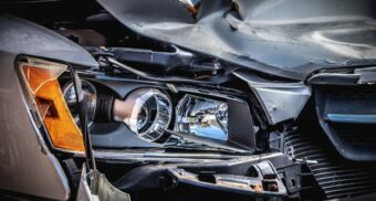 A close-up of a vehicle's damaged headlight and hood following a Brampton car crash.
