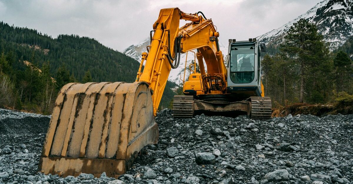 An excavator with its digging bucket resting on the ground.