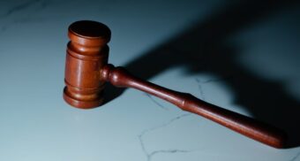 A photo of a wooden gavel on a marble table. (Photo: Wesley Tingey / Unsplash)