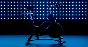 A photo of a stationary exercise bike in front of blue lights. (Photo: Gastro Editorial / Unsplash)