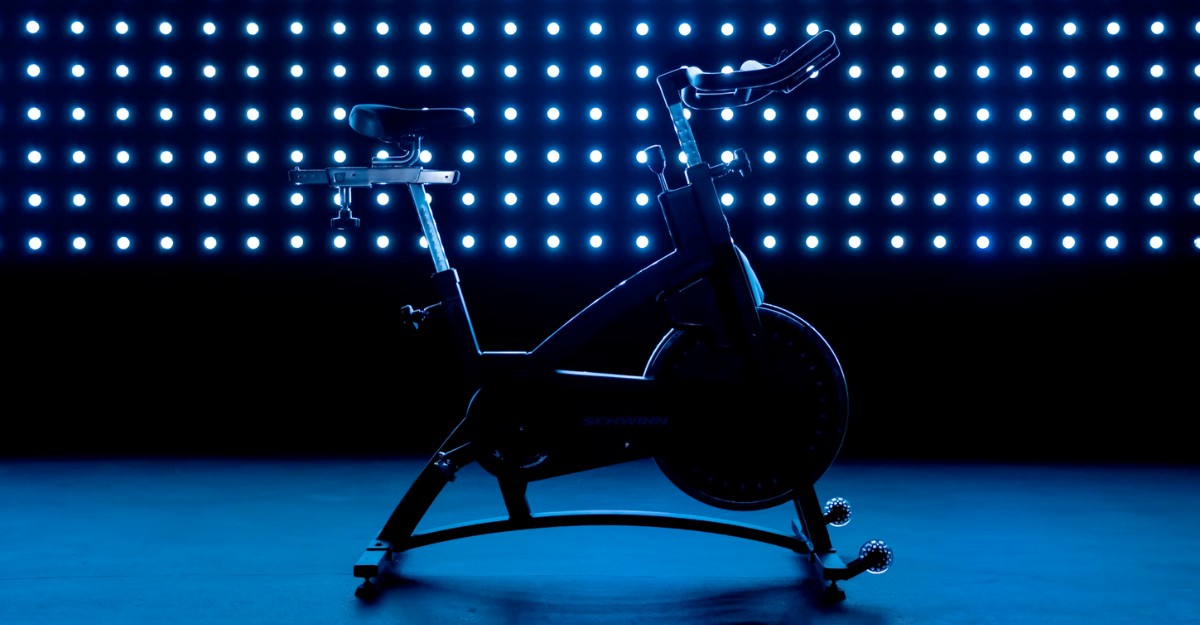 A photo of a stationary exercise bike in front of blue lights. (Photo: Gastro Editorial / Unsplash)