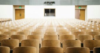 Rows of empty seats in a lecture hall at a university, college, or post secondary institution.